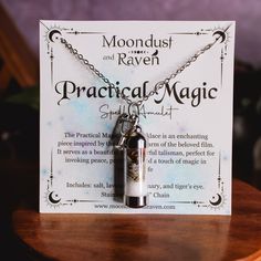 a card with a necklace on it that reads, moondust and raven practical magic