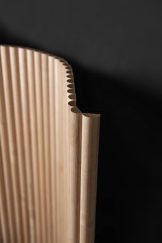 a close up of a wooden object on a black background with only the top section visible