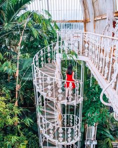 a woman standing on top of a white spiral staircase