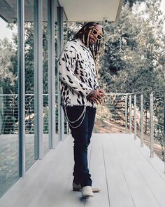 a man with dreadlocks is walking on a deck in front of a building