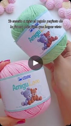 two balls of yarn in the shape of teddy bears are being held by someone's hand