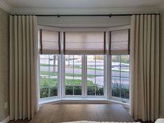 a living room with large windows and curtains