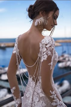 the back of a woman's wedding dress in front of boats