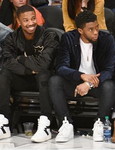 two men sitting next to each other at a basketball game