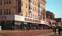 an old photo of people walking in front of a woolworth's store on the corner of a city street