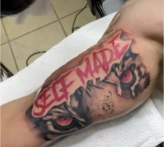 a man with a tiger tattoo on his arm that says see made in red ink