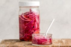 a jar filled with pickled red onions next to a glass container full of sliced radishes