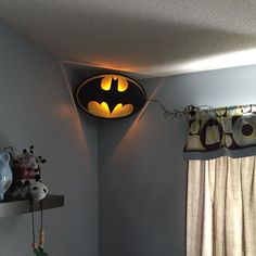 a batman light hanging from the ceiling in a child's bedroom