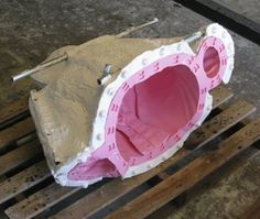 a pink object sitting on top of a wooden pallet