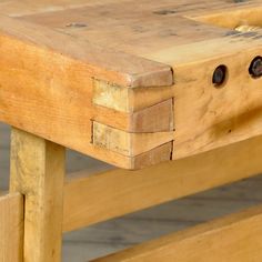 a close up of a wooden bench with holes in it