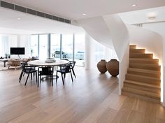 a living room filled with furniture and a spiral staircase leading up to the second floor