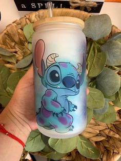 a hand holding a tumbler with an image of stitcher from the disney movie stitchers