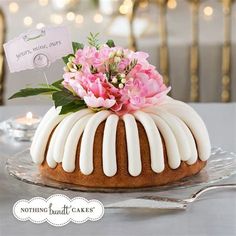 a bundt cake with white icing and pink flowers