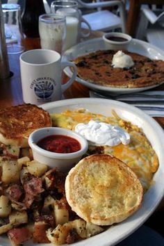 a breakfast plate with eggs, hash browns, pancakes and other food items on it