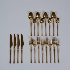 an assortment of gold colored forks and spoons