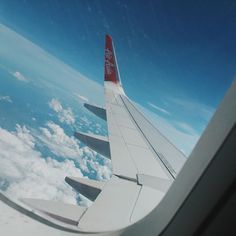 the wing of an airplane flying over clouds