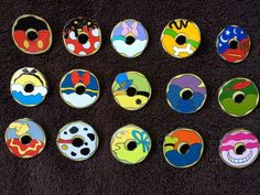 nine different colored donuts with faces painted on them are sitting on a black surface