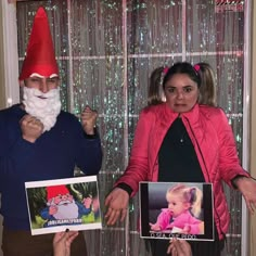 two people dressed as gnomes holding pictures and posing for the camera with one person wearing a santa claus hat