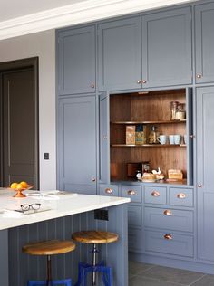 a kitchen with blue cabinets and stools