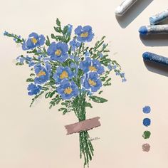 a bouquet of blue flowers is drawn on a piece of paper with crayons next to it