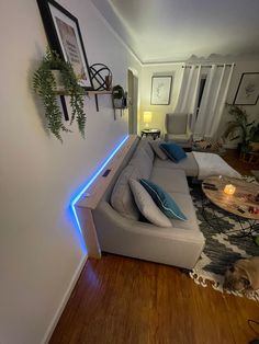 a living room filled with furniture and a light on the wall next to a couch