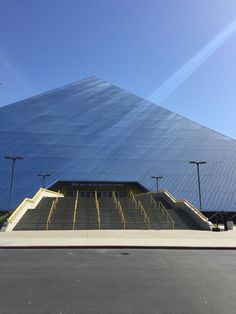 an empty parking lot in front of a large building with stairs leading up to it