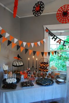 a table topped with cakes and cupcakes next to a cake stand filled with candles