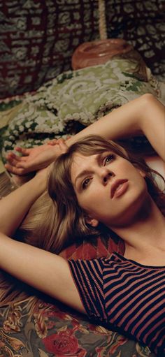 a beautiful young woman laying on top of a bed