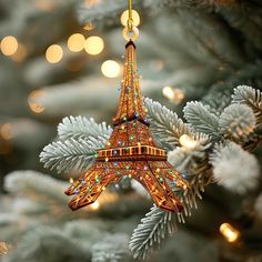 an ornament shaped like the eiffel tower hanging from a christmas tree