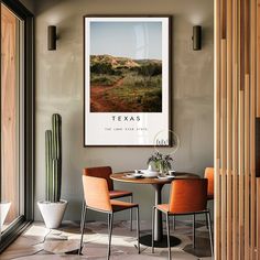 a dining room table with two chairs and a poster hanging on the wall above it