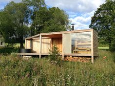 a small wooden cabin sitting on top of a lush green field