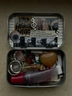 two tins filled with assorted items on top of a table