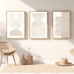 three framed art pieces hang on the wall above a chair and table in a minimalist living room