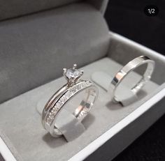 two wedding rings sitting in a box on display