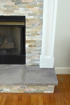 a fireplace with a stone mantle and wood floors