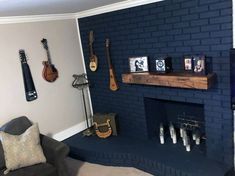 a living room with a fireplace and guitars on the wall next to an entertainment center