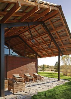 an outdoor covered patio with chairs and tables