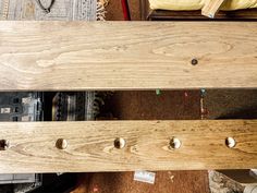 a wooden bench sitting on top of a floor next to a pile of boxes and other items