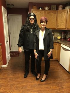 two women standing next to each other in a kitchen with wood floors and wooden cabinets