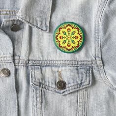 a yellow and red flowered design on a denim jacket button or lapel pin