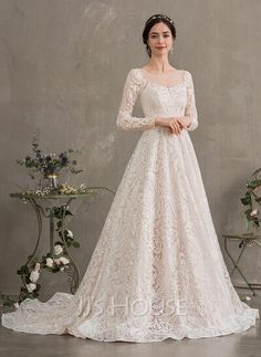 a woman in a white wedding dress standing next to a table with flowers on it