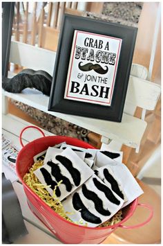 there is a red bucket filled with black and white napkins on top of the table