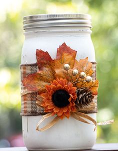 Decorative wide mouth Mason Jar painted in white color, hand painted Mason Jar décor for fall. These jars can be used as centerpiece on the tables , for storing dry items or as gifts . 12 quart 32 ounces  mason jars with wide mouth lid/band, hand painted in white color, decorated with orange plaid ribbon, twine bow ,artificial maple leaf ,sunflower, pine cone and golden beads.   These jars are painted using various coats of chalk paint,destressed and then sealed by waterproof wax coat. Please ke Crafts Using Glass Jars, Fall Jars Diy, Fall Wedding Mason Jar Centerpieces, Firefly Mason Jar Craft, Decorated Mason Jars Diy, Fall Jars Decorations, Fall Craft For Women, Fall Mason Jar Ideas, Fall Decor Ideas For Office Desk