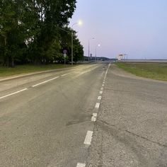 an empty street with no cars on it and trees lining the side of the road