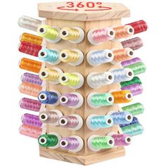 a wooden box filled with lots of spools of thread on top of a white background