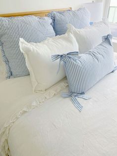 a bed with blue and white striped pillows