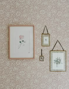 three framed pictures hang on the wall next to two small frames with flowers in them