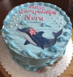 a blue cake decorated with a whale and the words altoz cumpleadess nora