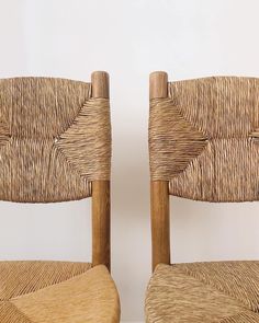 two wooden chairs sitting side by side next to each other