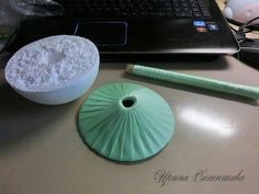 a laptop computer sitting on top of a desk next to a green container and pencil